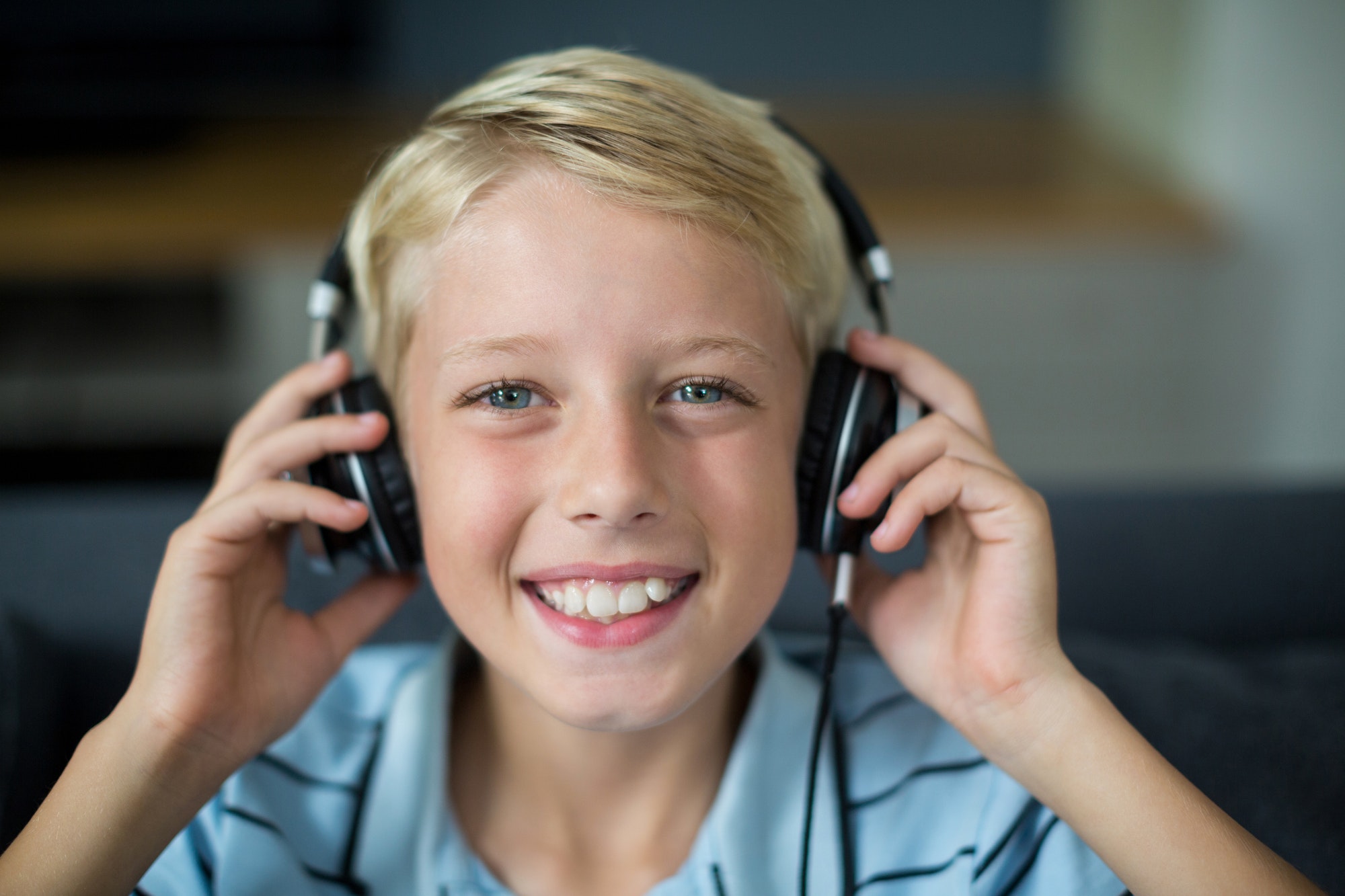 Smiling boy listening to music on headphones in living room